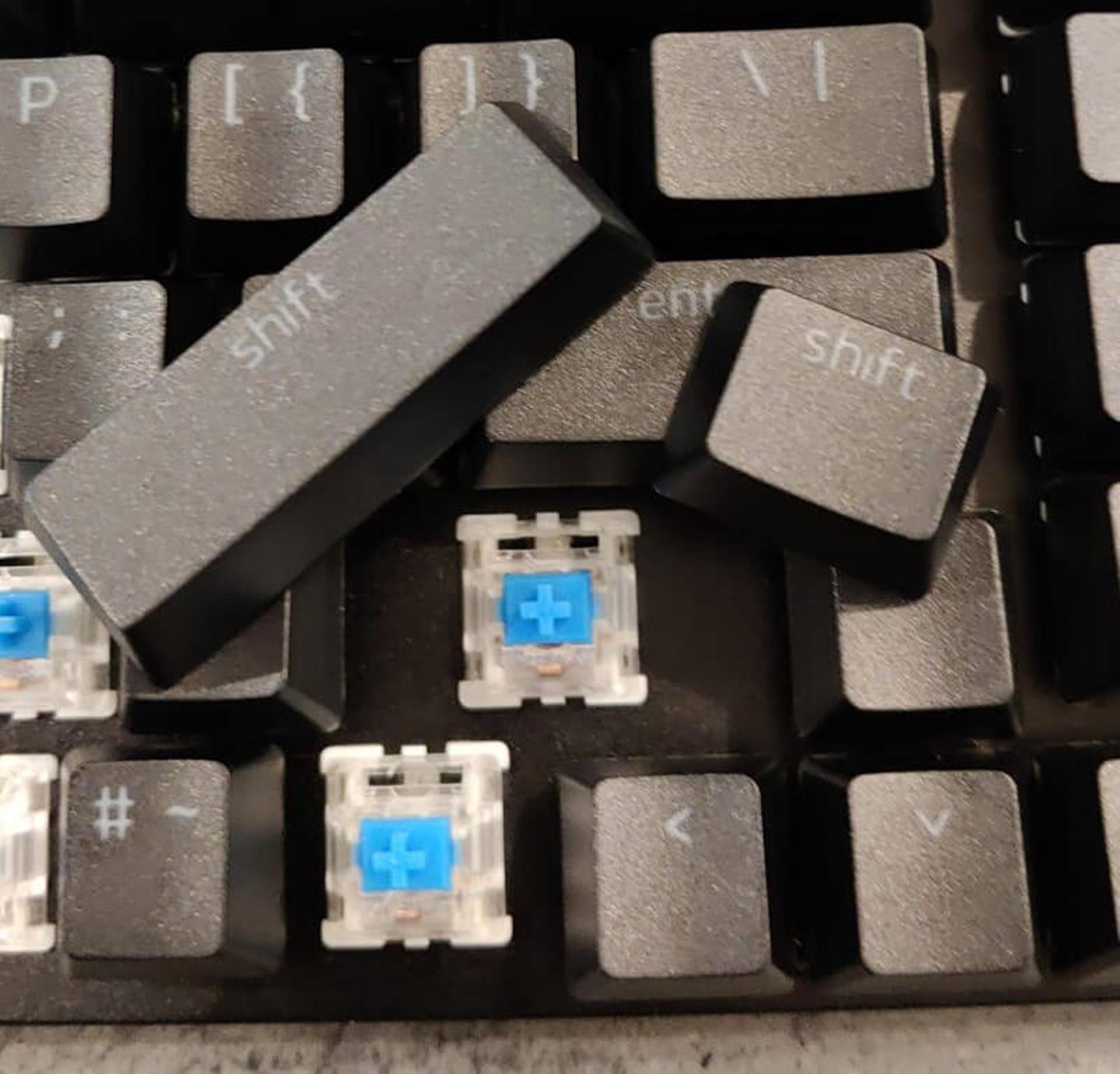 Several different sized shift keycaps next to a space on a keyboard that is not the same size as either